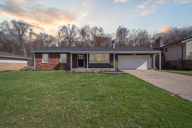 ranch-style house with concrete driveway, brick siding, a front lawn, and a garage