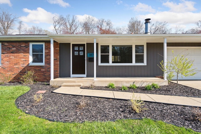 ranch-style house with driveway, covered porch, brick siding, and an attached garage