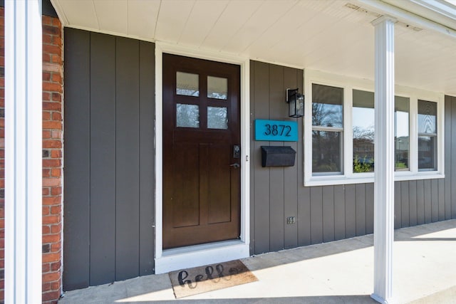 property entrance with covered porch and brick siding