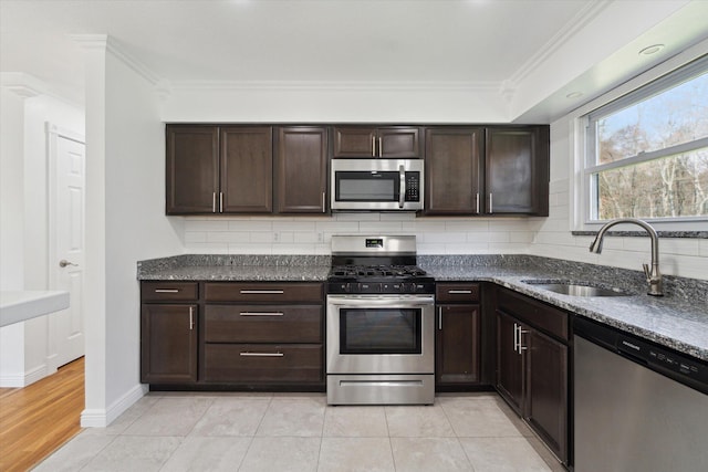 kitchen with tasteful backsplash, stainless steel appliances, crown molding, and a sink