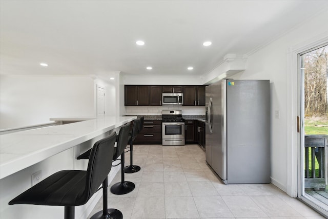 kitchen with light stone countertops, appliances with stainless steel finishes, crown molding, and plenty of natural light