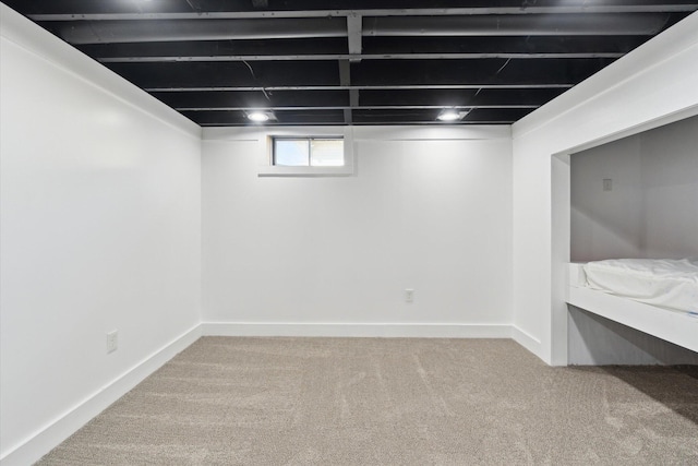 basement featuring carpet flooring and baseboards