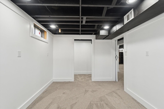 basement with baseboards, visible vents, and carpet