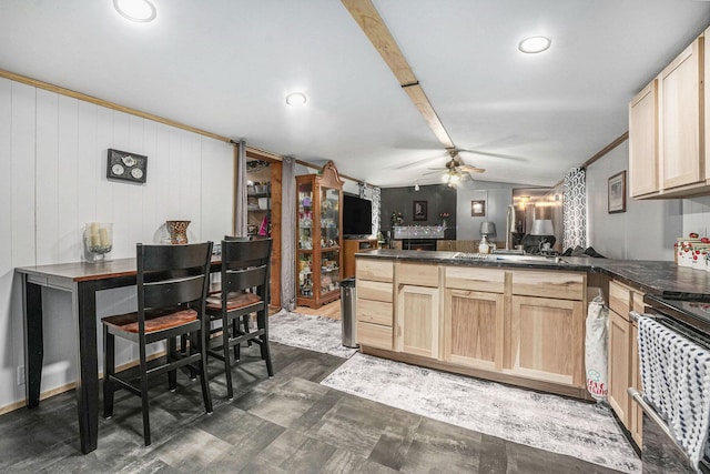kitchen featuring dark countertops, a ceiling fan, a peninsula, and light brown cabinets