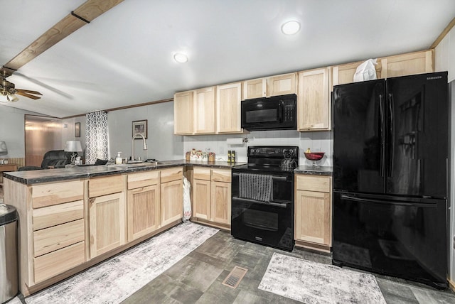 kitchen with light brown cabinetry, black appliances, dark countertops, a sink, and a peninsula