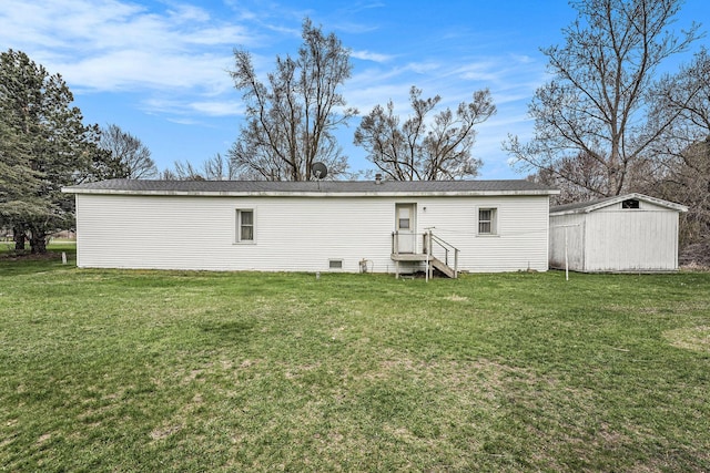 back of house with an outbuilding, a lawn, and a shed