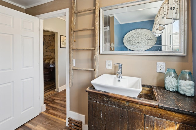 bathroom featuring ornamental molding, wood finished floors, and vanity