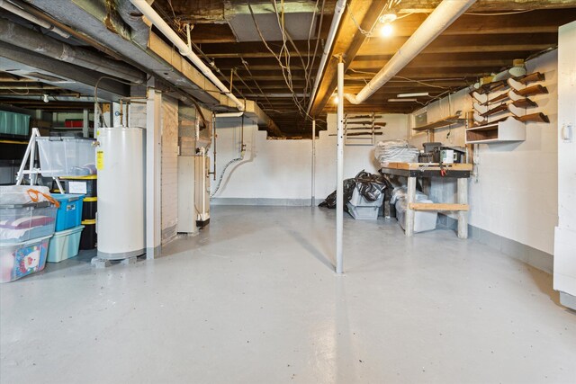 unfinished basement with baseboards and gas water heater
