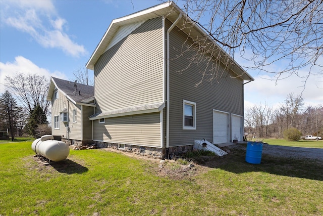 view of property exterior with an attached garage and a yard