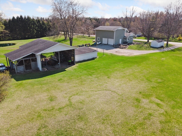 view of yard with a garage, a detached carport, and driveway