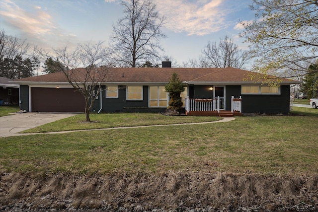 ranch-style home featuring concrete driveway, a front lawn, an attached garage, and a chimney