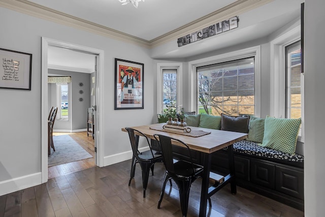 dining room featuring ornamental molding, dark wood-style floors, breakfast area, and baseboards