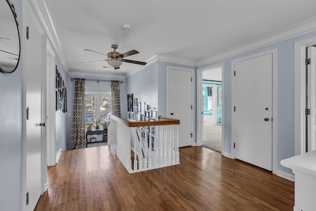 foyer with ornamental molding, ceiling fan, wood finished floors, and baseboards
