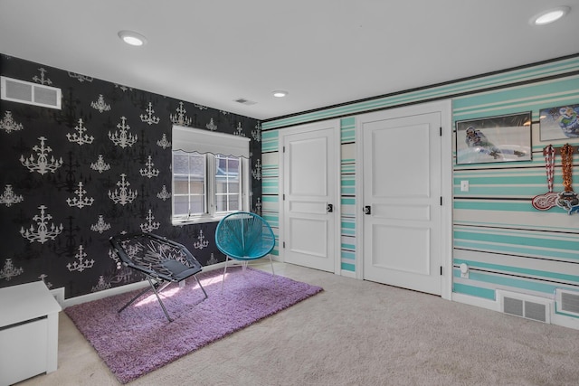 living area featuring visible vents, carpet floors, and wallpapered walls