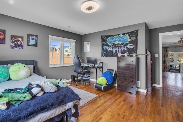 bedroom with wood finished floors and baseboards