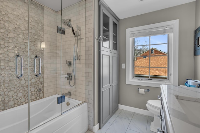 full bath with shower / bath combination with glass door, a sink, baseboards, toilet, and marble finish floor