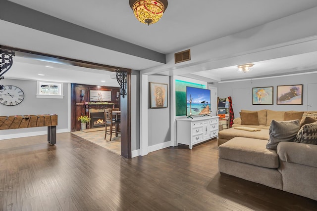 living room featuring visible vents, wood finished floors, and baseboards