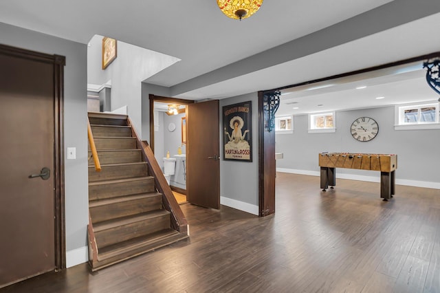 staircase with wood finished floors, recessed lighting, and baseboards