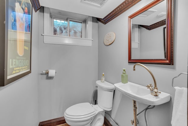 bathroom featuring visible vents, toilet, and a sink