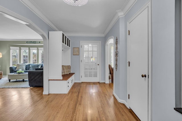 mudroom featuring baseboards, arched walkways, light wood finished floors, and crown molding