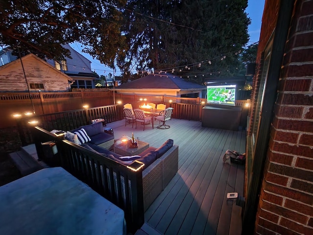 wooden terrace with an outdoor living space with a fire pit