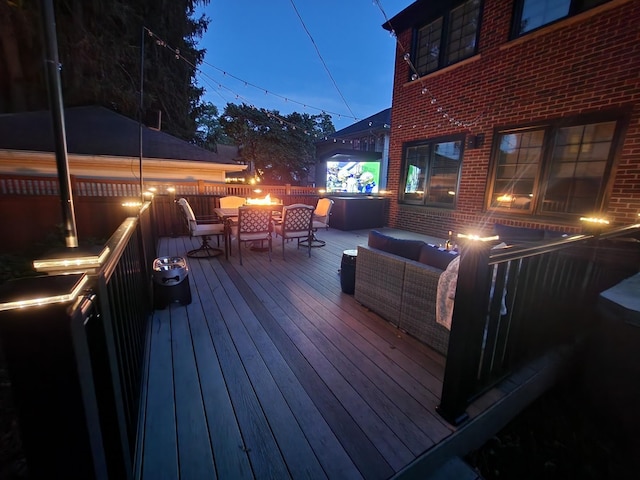 wooden deck featuring an outdoor living space with a fire pit