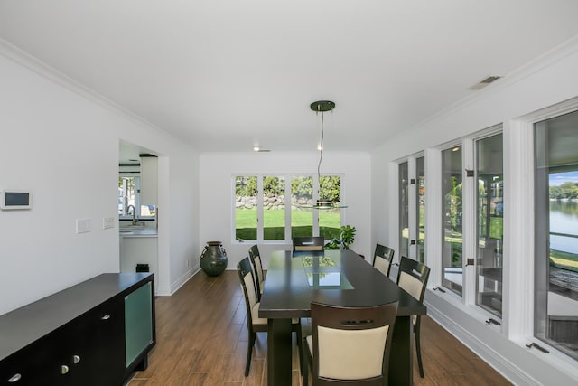 dining area featuring ornamental molding, dark wood-style floors, and baseboards