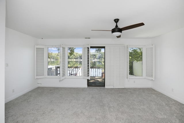 empty room featuring carpet flooring, ceiling fan, and a healthy amount of sunlight