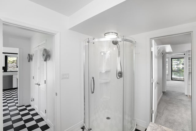 full bath featuring tile patterned floors, a stall shower, and baseboards