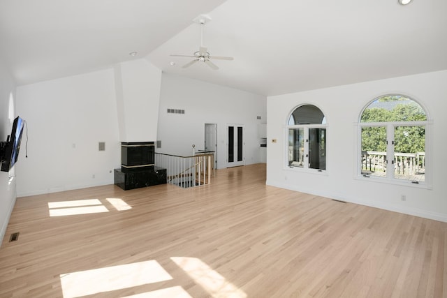 unfurnished living room with visible vents, a ceiling fan, light wood-style flooring, and high vaulted ceiling