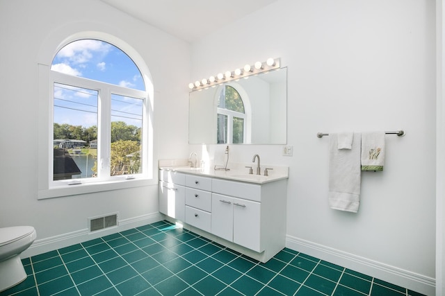 full bath with visible vents, a healthy amount of sunlight, and a sink