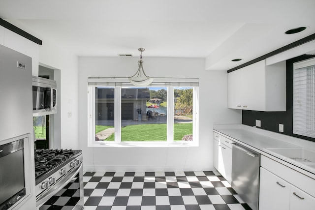 kitchen with white cabinets, stainless steel appliances, light countertops, and dark floors