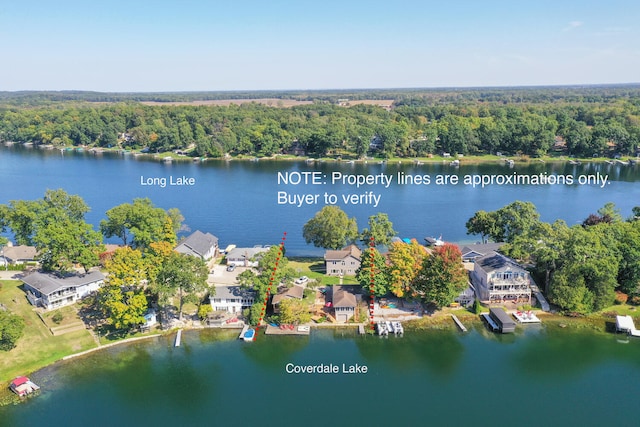 birds eye view of property with a wooded view and a water view