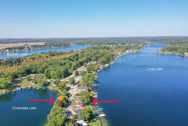 aerial view with a wooded view and a water view
