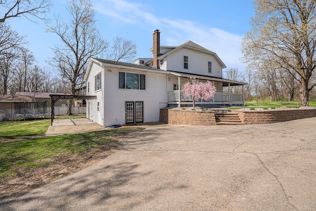 back of house featuring a patio, fence, french doors, and a chimney