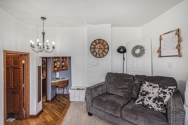 living area featuring baseboards, wood finished floors, and an inviting chandelier