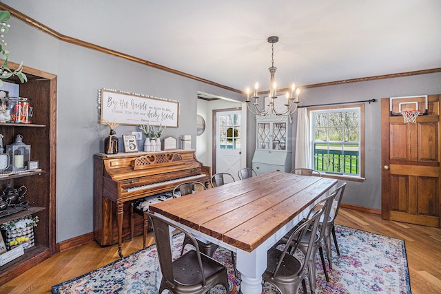 dining area with ornamental molding, a healthy amount of sunlight, a chandelier, and baseboards