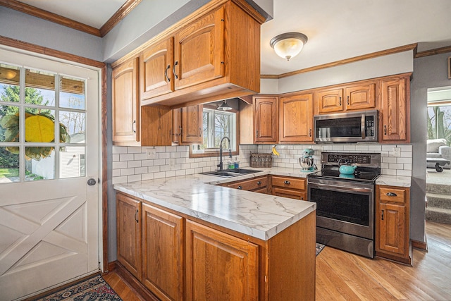 kitchen featuring light countertops, stainless steel appliances, crown molding, and a sink