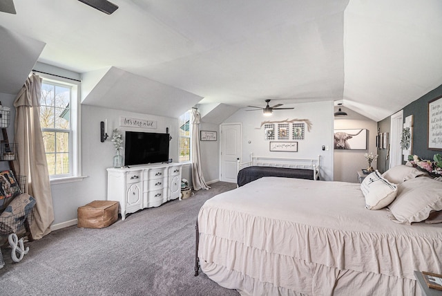 carpeted bedroom featuring lofted ceiling, ceiling fan, baseboards, and multiple windows