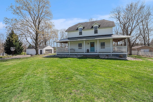 farmhouse-style home with covered porch, a detached garage, a front lawn, and metal roof