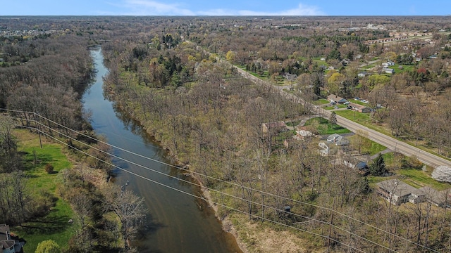 drone / aerial view with a forest view and a water view