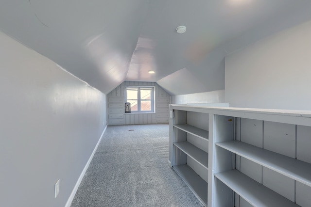 bonus room featuring vaulted ceiling, light colored carpet, and baseboards