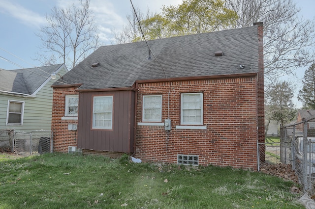 rear view of house featuring brick siding, roof with shingles, fence, and a chimney