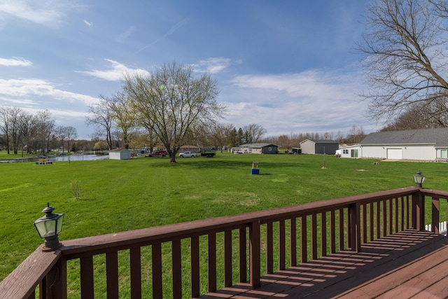 wooden deck with a lawn and a water view
