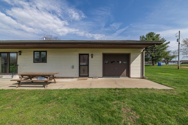 back of house with a yard, a patio area, and a garage