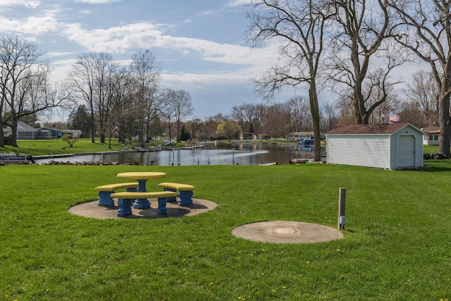 view of property's community featuring a yard, a shed, a water view, and an outdoor structure