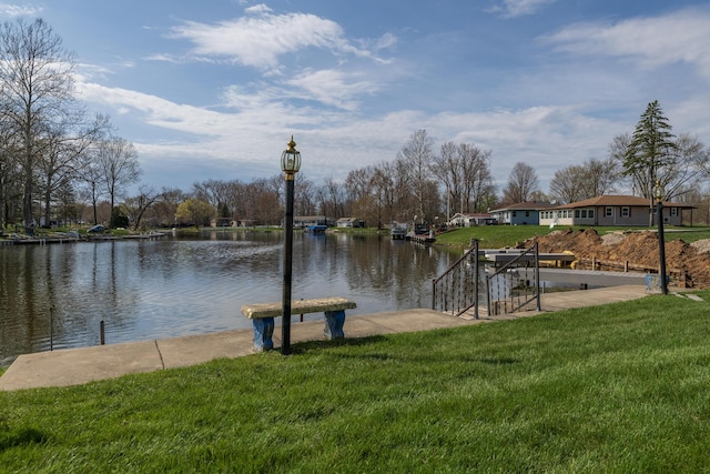 dock area with a water view and a lawn