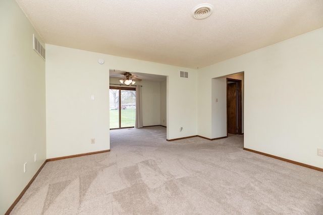 unfurnished room with visible vents, baseboards, and light carpet