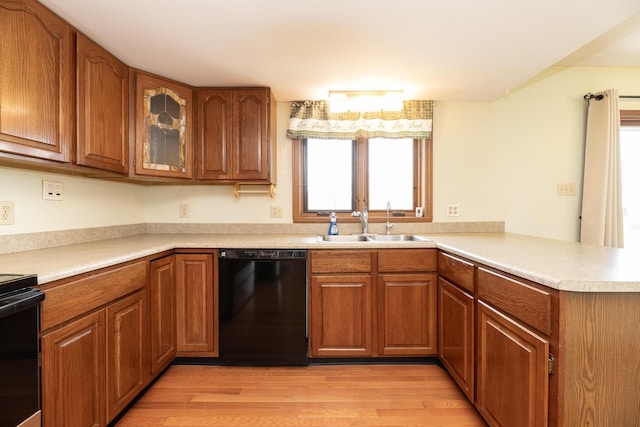 kitchen with black appliances, brown cabinets, and a sink