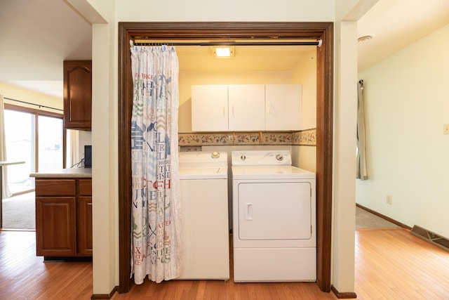 washroom featuring visible vents, cabinet space, independent washer and dryer, and light wood-type flooring